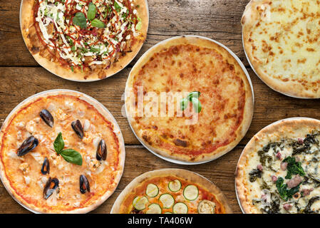 Variété de la pizza sur la table en bois Banque D'Images