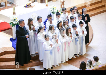 Zagreb, Croatie - Mai 5, 2019 : un groupe de jeunes filles et garçons vêtus de robes blanches avec prêtre et nun posant pour photographier à leur premier c Banque D'Images