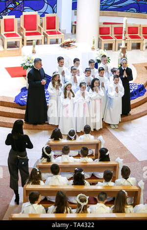 Zagreb, Croatie - Mai 5, 2019 : un groupe de jeunes filles et garçons vêtus de robes blanches avec prêtre et nun posant pour photographier à leur premier c Banque D'Images