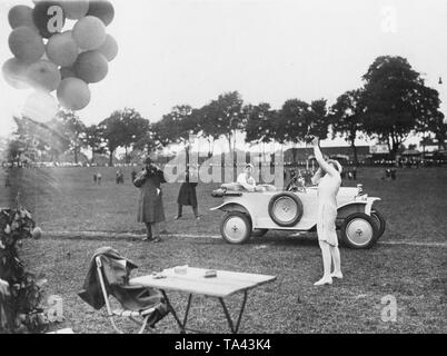 Le 29.05.1926, le Berliner Automobilklub a organisé un concours d'habiletés. Ici une femme essaie de tirer sur un ballon qui vole dans l'air. Derrière elle se trouve une autre femme dans une Opel Laubfrosch 4/12 PS, convertibles, 1924-1926. Banque D'Images