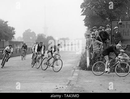 Les participants de la course cycliste pour journalistes sportifs à Berlin. Dans l'arrière-plan dans la brume, la tour de télévision de Berlin. Banque D'Images