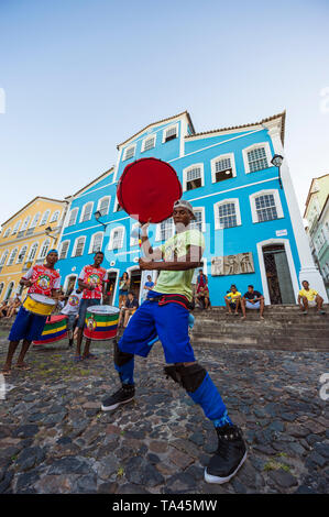 SALVADOR, BRÉSIL - Mars, 2018 : un batteur joue avec son en face de l'architecture coloniale colorée de Pelourinho, dans le cadre d'un projet social. Banque D'Images