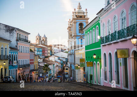 SALVADOR, BRÉSIL - Mars, 2018 : lumières de rue dot l'architecture coloniale colorée comme la nuit tombe sur la collines pavées de Pelourinho. Banque D'Images