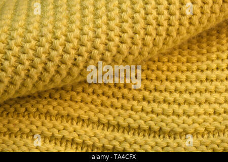 Contexte artistique à partir de tissu de laine tricoté jaune avec grandes boucles macro photographie Banque D'Images