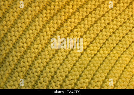 Contexte artistique à partir de tissu de laine tricoté jaune avec grandes boucles macro photographie Banque D'Images
