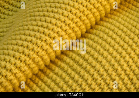 Contexte artistique à partir de tissu de laine tricoté jaune avec grandes boucles macro photographie Banque D'Images