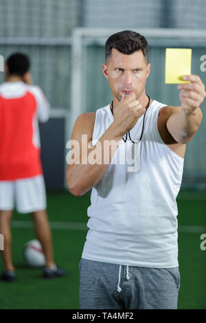 Arbitre de football montrant carte jaune pour les joueurs au cours du jeu Banque D'Images