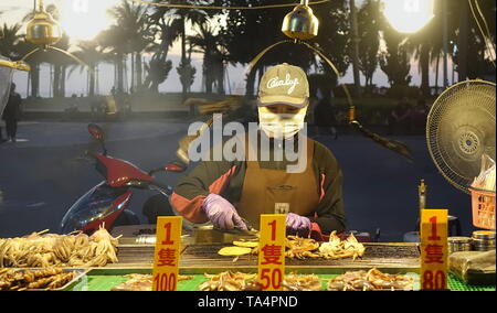 KAOHSIUNG, TAIWAN -- 22 DÉCEMBRE 2018 : Un vendeur de rue cuisiniers Calmar grillé près de la plage sur l'île de Cijin. Banque D'Images