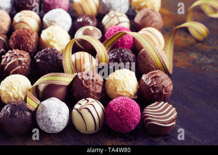 Grand choix de luxe autour du bonbon de chocolat balles avec un ruban d'or de fête fit tournoyer dans une vue d'arrière-plan close up Banque D'Images