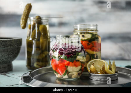 Les bocaux en verre avec des légumes fermentés sur table Banque D'Images