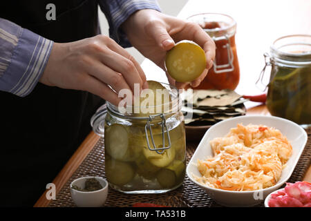 Femme avec de savoureux légumes fermentés dans la cuisine Banque D'Images