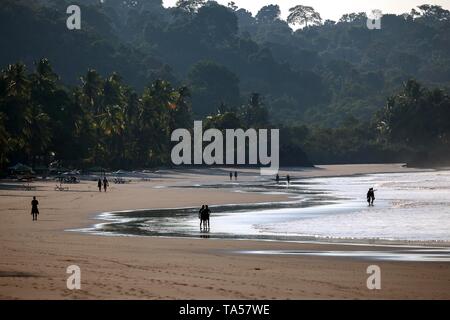 Les gens au Palm Beach de rétro-éclairage, Lumière du matin, la plage Playa Espadilla, Manuel Antonio National Park, province de Puntarenas, Costa Rica Banque D'Images