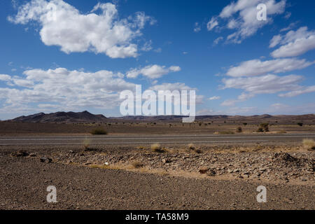 L'autoroute marocaine dotée d''un paysage de désert rocheux sur un road-trip de Marrakech à Merzouga, Maroc Banque D'Images