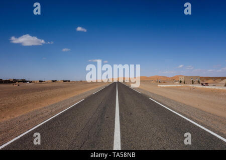 L'autoroute marocaine dotée d''un paysage désertique avec des dunes de sable à Merzouga, Maroc Banque D'Images