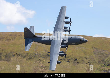 Un rare groupe de quatre avions Hercules C-130 de l'USAF voler à basse altitude dans la zone 7, boucle Mach près de Dolgellau, Pays de Galles, Royaume-Uni. Banque D'Images