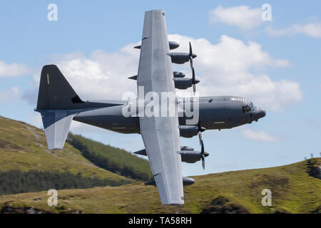 Un rare groupe de quatre avions Hercules C-130 de l'USAF voler à basse altitude dans la zone 7, boucle Mach près de Dolgellau, Pays de Galles, Royaume-Uni. Banque D'Images