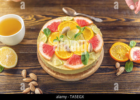 Matières gâteau d'agrumes avec le pamplemousse, l'orange, de lime et de citron à l'aide d'écrous et de menthe. La cuisson à la maison d'été en bonne santé avec des ingrédients légumes dessert vegan Banque D'Images