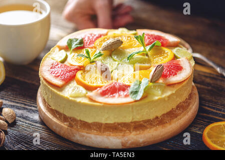 Matières gâteau d'agrumes avec le pamplemousse, l'orange, de lime et de citron à l'aide d'écrous et de menthe. Dessert d'été frais et sain. Nourriture vegan fait maison Banque D'Images