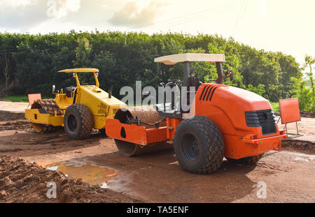 La construction de routes avec rouleau compresseur / jaune et orange à double rouleau tracteur moderne working on construction site Banque D'Images