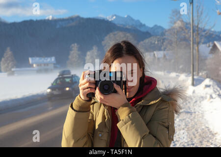 Une femme photographe de prendre des photos de paysage d'hiver. Banque D'Images