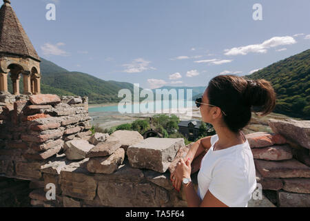 Jeune femme regarde l'église et à la forteresse en Géorgie en journée ensoleillée Banque D'Images