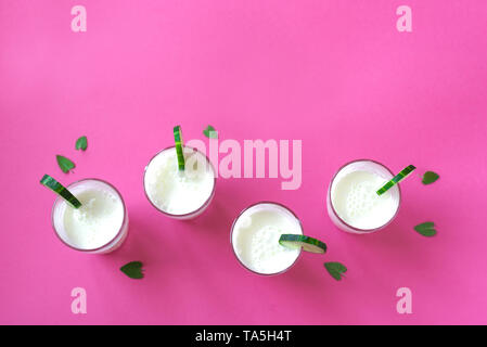 Ayran, boisson au yogourt fait maison (le kéfir, lassi) avec concombres - été saine boisson fraîche sur rose, copiez l'espace. Banque D'Images