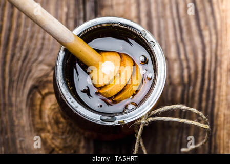 Pot de miel en verre et en bois à balancier, vue du dessus du miel Banque D'Images