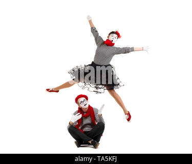 Smiling mimes en chemises à rayures. surpris l'homme et femme saut isolé sur fond blanc Banque D'Images