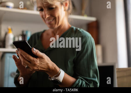 Female carpenter using mobile phone in workshop Banque D'Images