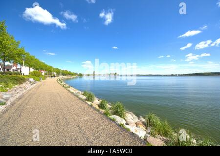 Schleswig, Deutschland. Le 11 mai, 2019. 11.05.2019, la promenade sur le Schlei dans Schleswig avec superbe temps de printemps avec ciel bleu et Schonwetterwolken. Dans le contexte le Petri Dom ainsi que le port de plaisance de l'Schleisegelclub (SSC). Utilisation dans le monde entier | Credit : dpa/Alamy Live News Banque D'Images