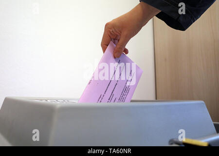 Rostock, Allemagne. 17 mai, 2019. Un électeur met une enveloppe avec son bulletin rempli de papier pour les élections européennes le 26 mai 2019 dans une boîte à la liste électorale et le vote par bureau. Le vote postal est de plus en plus populaire. Dans les élections fédérales de 2017 dans le Mecklembourg-Poméranie-Occidentale, 23,9  % de tous les électeurs de voter par lettre, contre 18,2  % quatre ans plus tôt. Crédit : Bernd Wüstneck/dpa-Zentralbild/ZB/dpa/Alamy Live News Banque D'Images