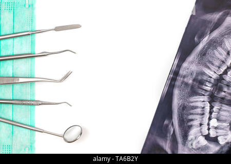 Outils de dentiste sur masque et x-ray photo. Banque D'Images