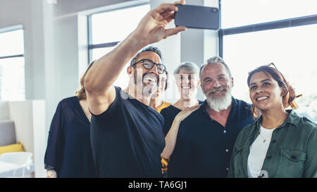 Happy group of businesspeople smiling photo et selfies faire. Les gens d'affaires multi-ethnique en tenant en selfies office. Banque D'Images