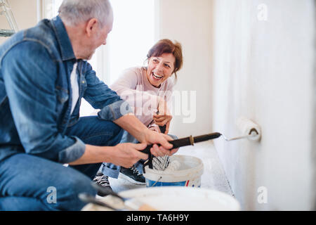 Peinture des murs Senior couple in new home, réinstallation concept. Banque D'Images