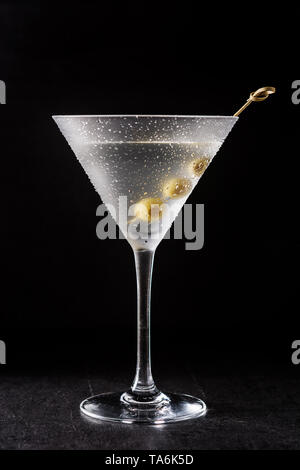 Dry Martini classique avec des olives sur fond noir Banque D'Images