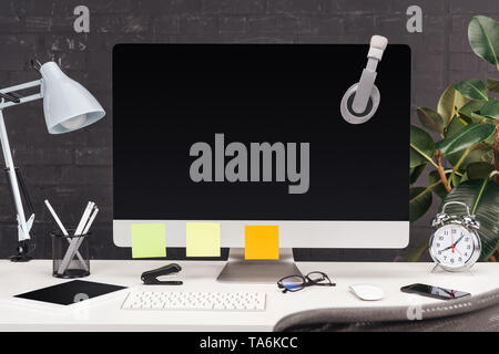 Travail avec des écouteurs et vide les notes sur l'écran de l'ordinateur, et lampe de table blanc sur papier Banque D'Images