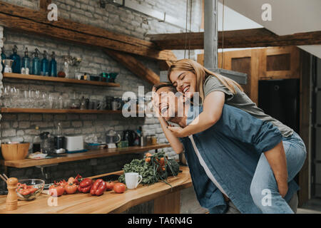 Joli jeune couple de s'amuser ensemble à cuisine rustique Banque D'Images