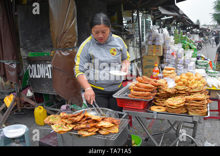 Hoi An, Vietnam - 20 décembre 2017. Un vendeur de rue prépare la nourriture à son étal dans le quartier historique de l'UNESCO énumérés en vietnamien ville de Hoi An. Banque D'Images