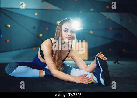 Gymnaste girl doing Stretching Exercices de réchauffement. Voir de jeunes femme sports au gym crossfit Banque D'Images