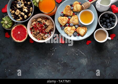 Petit-déjeuner ou brunch concept sur fond sombre. Vue de dessus avec l'exemplaire de l'espace. Petit déjeuner sain. Petit-déjeuner sain crêpes, fruits secs, café, barres granola. Banque D'Images