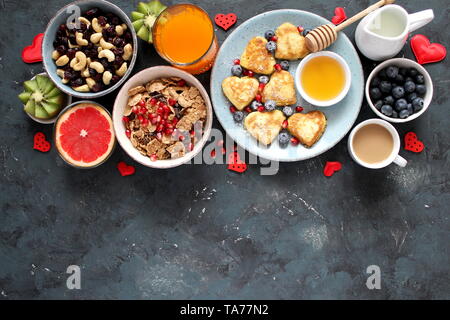 Petit-déjeuner ou brunch concept sur fond sombre. Vue de dessus avec l'exemplaire de l'espace. Petit déjeuner sain. Petit-déjeuner sain crêpes, fruits secs, café, barres granola. Banque D'Images