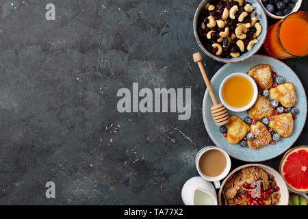 Petit-déjeuner ou brunch concept sur fond sombre. Vue de dessus avec l'exemplaire de l'espace. Petit déjeuner sain. Petit-déjeuner sain crêpes, fruits secs, café, barres granola. Banque D'Images