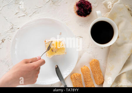 Tenir la main des personnes et de l'alimentation à la cuillère et couteau manger sucré gâteau sur une assiette, vaisselle, vue du dessus Banque D'Images