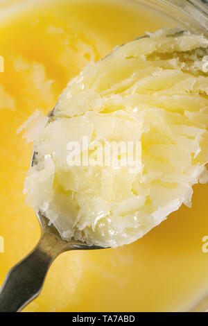 Le ghee fondu maison beurre clarifié dans ouvrir un bocal en verre et cuillère. Contexte alimentaire macro Close up Banque D'Images