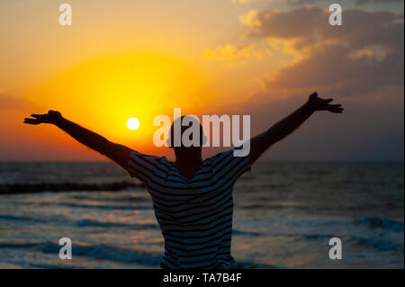 Silhouette image de l'homme levant les mains avec Ray of Light Banque D'Images