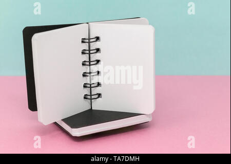 Deux ordinateurs portables sur un fond vert, rose et bleu, avec un espace réservé au texte Banque D'Images