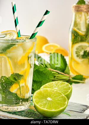 Boisson rafraîchissante limonade avec les citrons, les feuilles de menthe, citron vert dans un verre , à côté de l'ingrédients pour faire un cocktail Banque D'Images