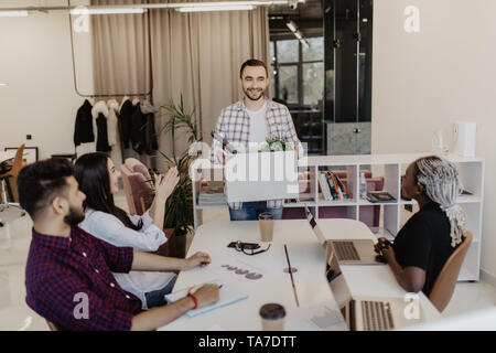 L'introduction de nouveaux employé de bureau à un collègue. Patron et collègues de l'accueil juste engagé les États rejoindre team holding box sur le premier jour de travail. Banque D'Images