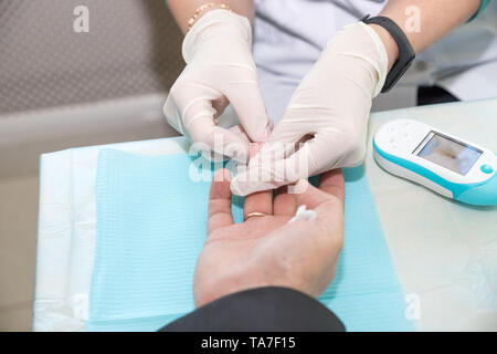Médecin prendre échantillon de sang au doigt du garçon. Concept du diabète. Le sucre dans le sang. Concept de soins de santé. Jeune homme en uniforme. Manteau blanc. Medical Banque D'Images