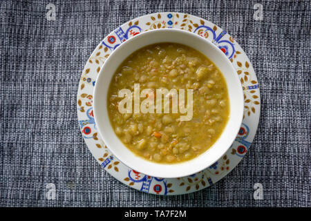 Soupe aux pois traditionnelle finlandaise sans viande sur une belle assiette, bol finlandais et tapis de table Banque D'Images